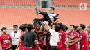 Para pemain Indonesia All Start U-20 mengangkat pelatih Ilham Romadhona saat merayakan kemenangan atas Bali United U-18 pada pertandingan IYC 2021 di Jakarta International Stadium, Jakarta, Selasa (19/4/2022). Indonesia All Stars U-20 menang atas Bali United U-18 2-1. (Liputan6.com/Faizal Fanani)