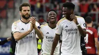 Pemain Real Madrid, Vinicius Junior, Nacho dan Aurelien Tchouameni merayakan kemenangan atas Osasuna pada laga pekan ke-29 La Liga 2023/2024 di Stadion El Sadar, Sabtu (16/03/2024). (AP Photo/Alvaro Barrientos)