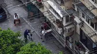 Warga berfoto di halaman saat lockdown akibat virus corona COVID-19 di Distrik Jing'an, Shanghai, China, 21 April 2022. (HECTOR RETAMAL/AFP)