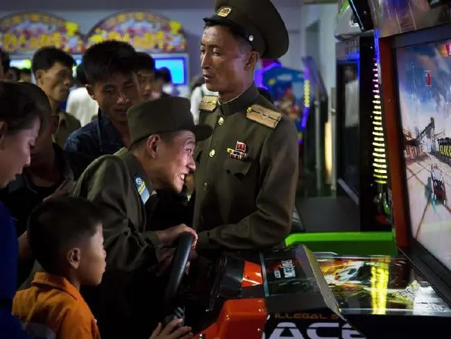 Seorang prajurit Korut terlihat sedang memainkan game arcade di Pyongyang Pleasure Park. Pihak berwenang Korea Utara telah mendorong minat olahraga yang lebih luas di negara ini (AP)