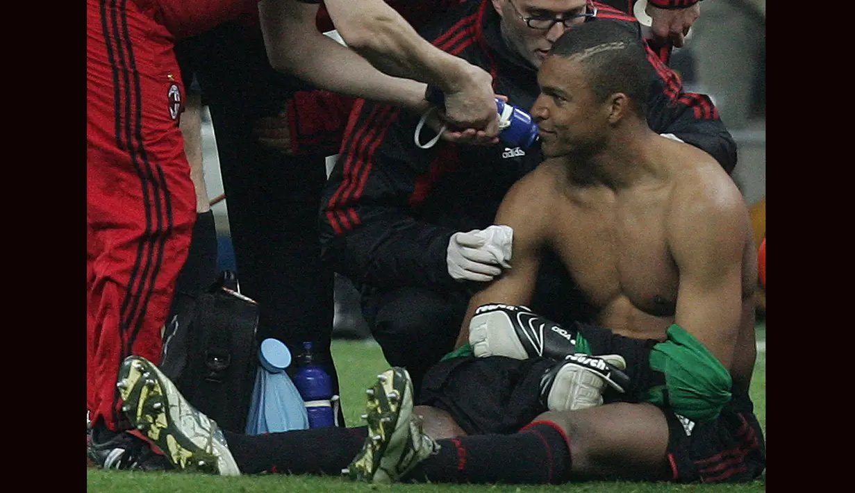 Kiper AC Milan, Dida mendapatkan perawatan dari tim medis setelah sempat terkena lemparan flare yang dilontarkan fans fanatik Inter Milan pada laga leg kedua babak perempatfinal Liga Champions 2004/2005 di San Siro Stadium, Milan (12/4/2005). (AFP/Paco Serinelli)