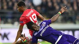 Striker Manchester United, Marcus Rashford, berebut bola dengan bek Anderlacht, Serigne Mbodji, pada laga Liga Europa di Stadion Constant Vanden Stock, Belgia, Kamis (13/4/2017). Kedua klub bermain imbang 1-1. (AFP/Emmanuel Dunand)