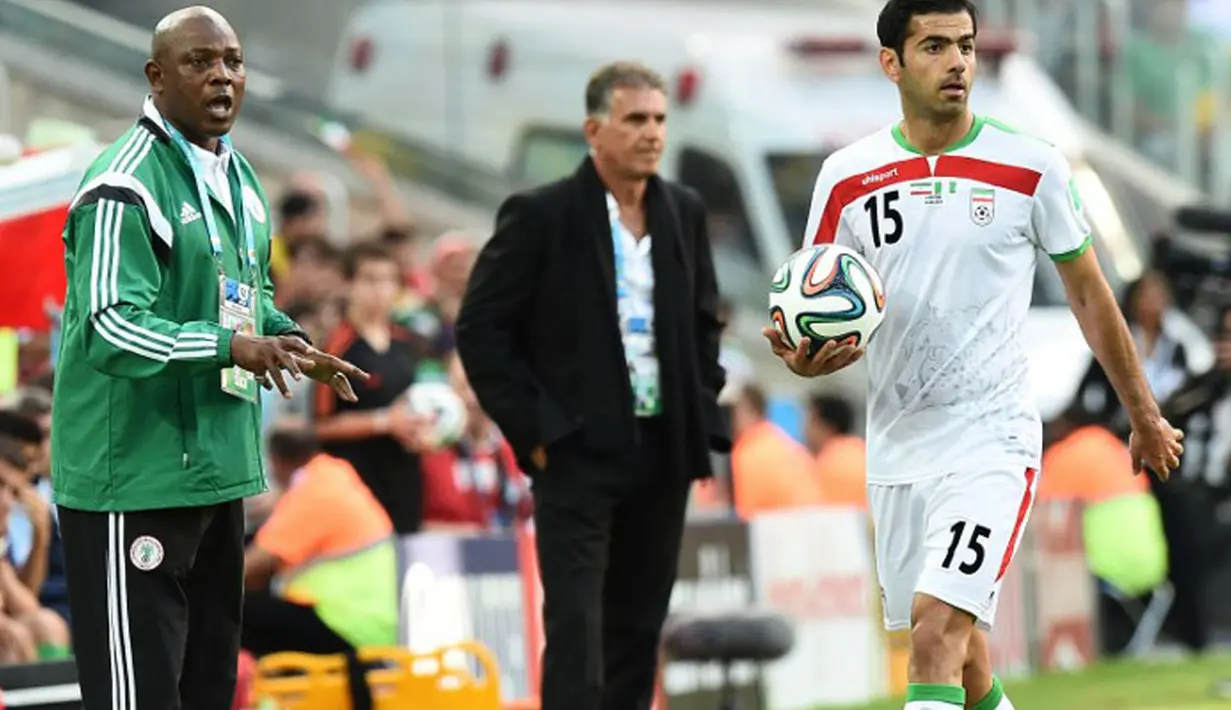 Iran dan Nigeria harus puas bermain imbang 0-0. Tampak, pelatih Nigeria, Stephen Keshi (kiri) terlihat memberikan arahan kepada timnya saat berlaga di babak penyisihan Piala Dunia Grup F, Baixada Arena, Brasil, (17/6/2014). (AFP PHOTO/Jewel Samad)