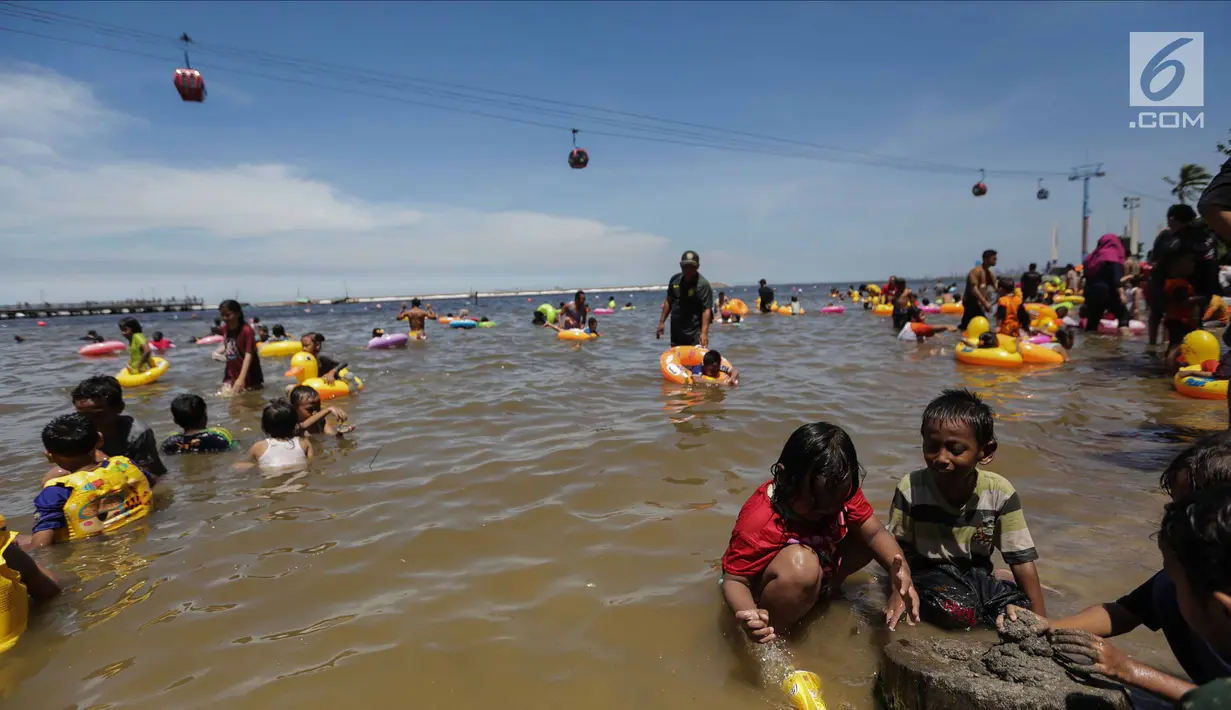 Sejumlah anak bermain pasir di pinggir pantai Ancol, Jakarta, Senin (25/12). Ancol tetap menjadi primadona tempat wisata bagi warga Jakarta dan sekitar untuk mengisi libur Natal 2017. (Liputan6.com/Faizal Fanani)