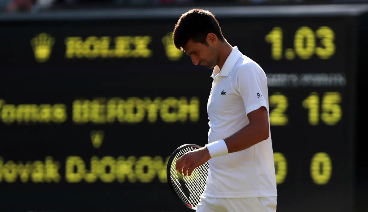 Petenis Serbia, Novak Djokovic berjalan di lapangan pada babak perempatfinal Wimbledon 2017 saat bertemu petenis Ceko, Tomas Berdych, Rabu (12/7). Djokovic harus menyerah dari Berdych saat pertandingan memasuki set kedua. (Gareth Fuller/PA via AP)