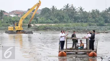 Petugas dari Pemprov DKI Jakarta mengamati alat berat yang tengah dioperasikan untuk melakukan pengerukan di Setu Mangga Bolong, Jakarta Selatan, Rabu (30/11). Pengerukan lumpur dan teratai dilakukan guna mencegah pendangkalan. (Liputan6.com/Yoppy Renato)