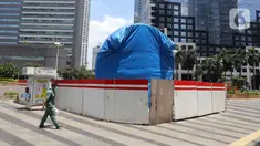 Warga berjalan dekat proyek pembangunan Tugu Sepeda di  kawasan Jenderal Sudirman, Jakarta, Rabu (22/9/2021). Dinas Perhubungan DKI Jakarta memastikan pembangunan Tugu Sepeda masih berlanjut, dan pembangunnya hingga saat ini telah mencapai 90 persen. (Liputan6.com/Herman Zakharia)