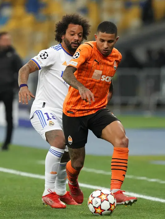 Pemain Real Madrid Marcelo (kiri) berebut bola dengan pemain Shakhtar Donetsk pada pertandingan grup D Liga Champions di Stadion Olympiyskiy, Kyiv, Ukraina, Selasa (19/10/2021). Real Madrid menang 5-0. (AP Photo/Efrem Lukatsky)