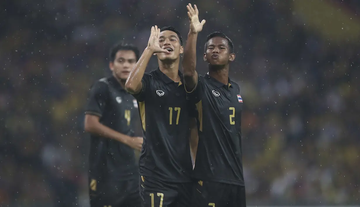 Gaya pemain Thailand, Rattanakorn Maikami (tengah) dan Sasalak Haiprakhon (kanan) merayakan gol ke gawang Malaysia  pada final sepak bola putra SEA Games 2017 di Stadion Shah Alam, Malaysia (29/8/2017). Thailand menang 1-0. (AP/Vincent Thian)