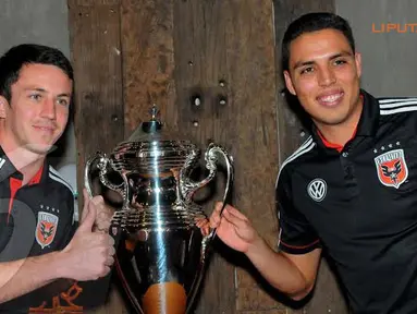 Gelandang DC United, Lewis Neal dan Luis Silva tampak mengangkat piala sebagai simbol laga persahabatan (Liputan6.com/Faisal R Syam).