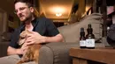 Brett Hartman mendiskusikan penggunaan ekstrak ganja TreatWell untuk mengatasi radang sendi pada anjingnya, Brutus, di Los Angeles, 8 Juni 2017. TreatWell merupakan produk baru dari ganja medis untuk penyembuhan bagi hewan peliharaan. (Robyn Beck/AFP)