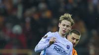 Gelandang Barcelona Frenkie de Jong berebut bola dengan gelandang Galatasaray Galatasaray Berkan Kutlu pada leg kedua 16 besar Liga Europa di NEF Stadyumu, Jumat (18/3/2022) dini hari WIB. Hasil Galatasaray vs Barcelona berakhir dengan skor 1-2. (AP Photo)