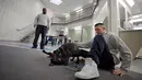 Narapidana Justin Martin dan Jonathan Ladson melihat aksi anak-anak anjing bermain di Penjara Merrimack County, Boscawen, New Hampshire, AS, Selasa (8/1). Anak-anak anjing yang dirawat para narapidana masih berumur 10 minggu. (AP Photo/Elise Amendola)
