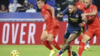 Penyerang Lyon, Memphis Depay, berebut bola dengan pemain Nimes pada laga lanjutan Liga Prancis di Stadion Groupama, Sabtu (19/9/2020) dini hari WIB. Lyon bermain imbang 0-0 atas Nimes. (AP Photo/Laurent Cipriani)