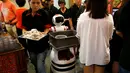 Robot mengumpulkan piring-piring tamu yang telah kotor di Chilli Padi Nonya Cafe, Singapura, (6/7).Pengembangan robot di Singapura masih dalam uji coba tetapi sudah banyak perusahaan yang ingin memperkejakan robot. (REUTERS / Edgar Su)