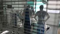 Petugas kesehatan merawat pasien terinfeksi Covid-19 di unit perawatan intensif rumah sakit Timone, di Marseille, Prancis selatan, Rabu (5/1/2022). Prancis mencatat rekor kasus baru Covid-19 dalam sehari pada Rabu waktu setempat dengan 335.000 tambahan kasus baru infeksi. (Nicolas TUCAT / AFP)