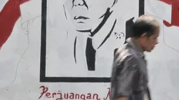 Pejalan kaki melintas di depan mural Bung Karno di Jalan Kolonel Sugiono, Jakarta, Selasa (13/8/2019). Mural dalam rangka menyambut Hari Kemerdekaan pada 17 Agustus itu sekaligus untuk mempercantik jalanan Ibu Kota. (merdeka.com/Iqbal S Nugroho)