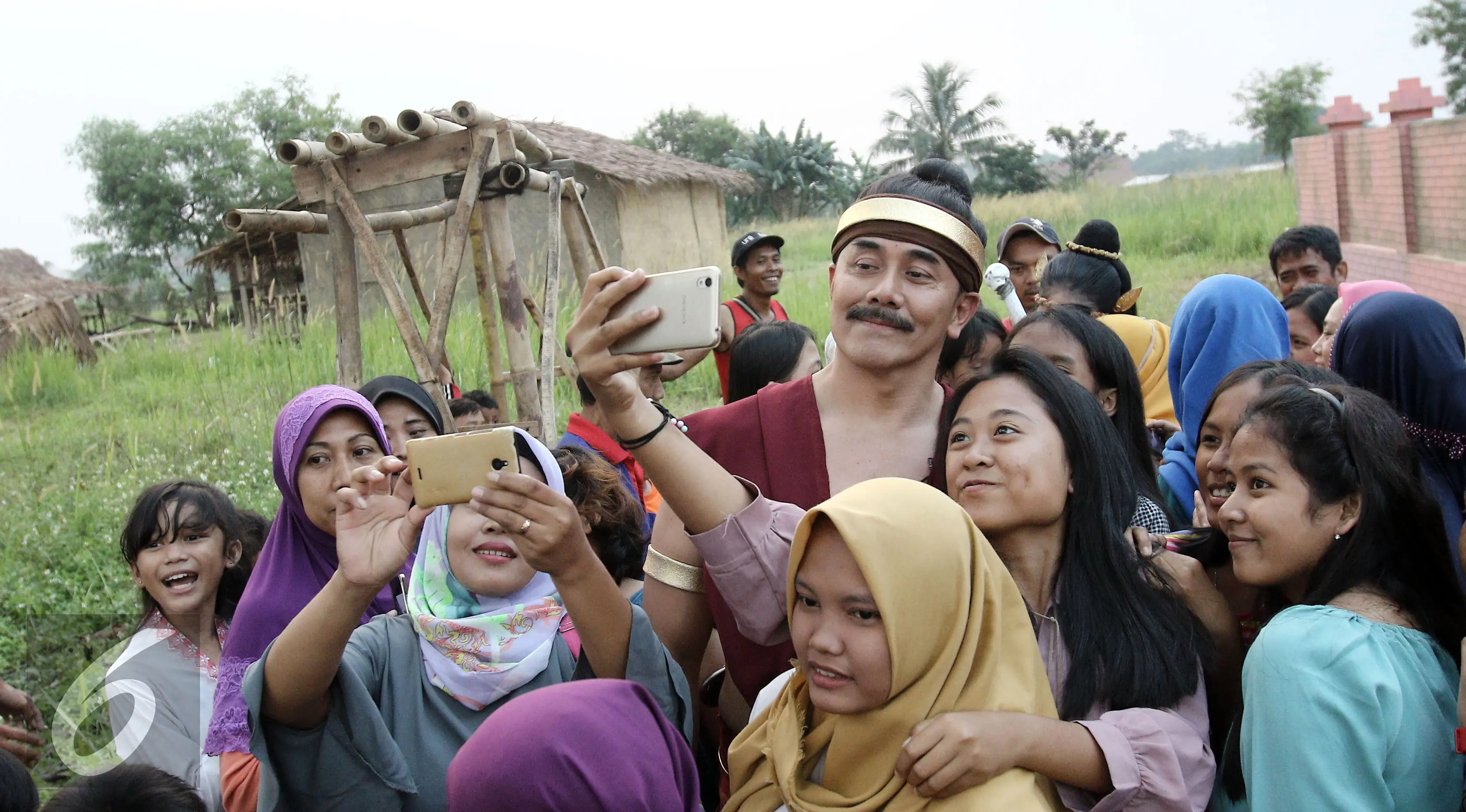 Salah satu bintang Saur Sepuh The Series, Fendy Pradana memenuhi permintaan warga untuk foto bareng di sela-sela syuting di kawasan Bogor, Jawa Barat, Rabu (2/8/2017). (Herman Zakharia/Liputan6.com) 