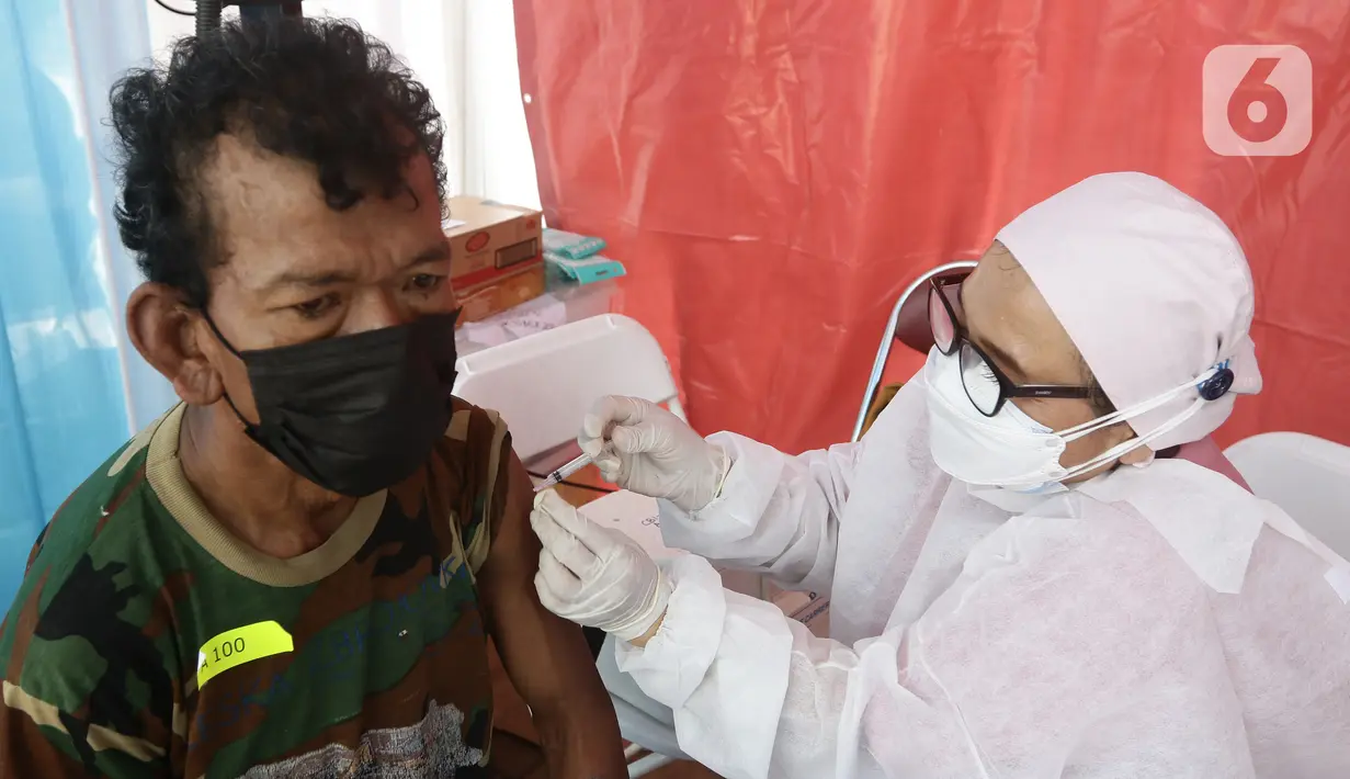 Vaksinator menyuntikkan vaksin Sinovac kepada warga di area TPST Bantargebang, Kota Bekasi, Jumat (29/10/2021). 300 dosis vaksin perhari disiapkan untuk vaksinasi pertama maupun kedua bagi masyarakat dan komunitas pemulung di sekitar TPST Bantargebang. (Liputan6.com/Helmi Fithriansyah)