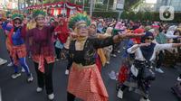 Para perempuan dari segala umur menggelar Flashmob Poco-poco Berkebaya bersama kelompok perempuan lainnya di Bundaran HI, Jakarta, Minggu (14/7/2024). (Liputan6.com/Herman Zakharia)