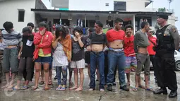 15 pria dan 5 wanita yang berhasil diamankan petugas pada penggerebekan di kawasan Bendi Paninggaran, Tanah Kusir, Jakarta, Rabu (2/3). Mereka kedapatan tengah mengisap sabu di rumah yang terletak di pinggir rel kereta. (Liputan6.com/Gempur M Surya)