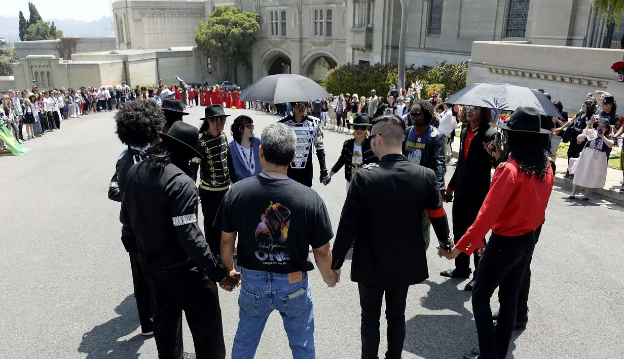 Beberapa fans terlihat mengheningkan cipta pada peringatan 5 tahun pasca kematian Michael Jackson, California, Rabu (25/6/14). (REUTERS/Kevork Djansezian)