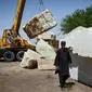 Para pekerja memindahkan marmer (The Guardian)