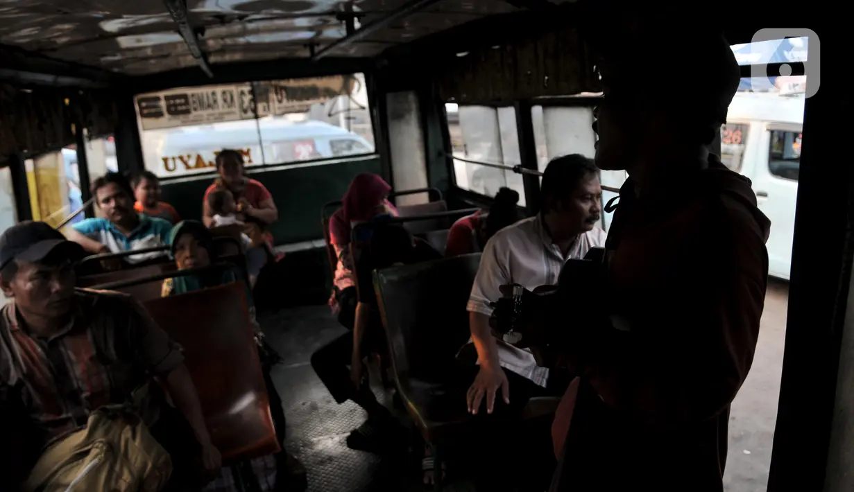 Sejumlah penumpang menyaksikan pengamen di dalam Metromini 53, Jakarta, Selasa (12/11/2019). Mungkin ada benarnya warga Ibu Kota kini lebih memilih moda transportasi kekinian yang telah dilengkapi AC. (merdeka.com/Iqbal Nugroho)