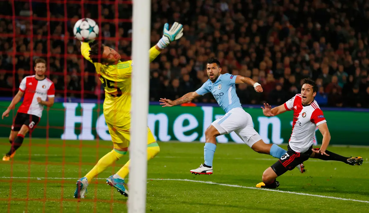 Pemain Manchester City, Sergio Aguero menendang bola melewati kiper Feyenoord untuk mencetal gol dalam laga perdana babak penyisihan Grup F Liga Champions di De Kuip, Rabu (13/9). Manchester City menaklukkan Feyenoord 4-0. (AP Photo/Peter Dejong)