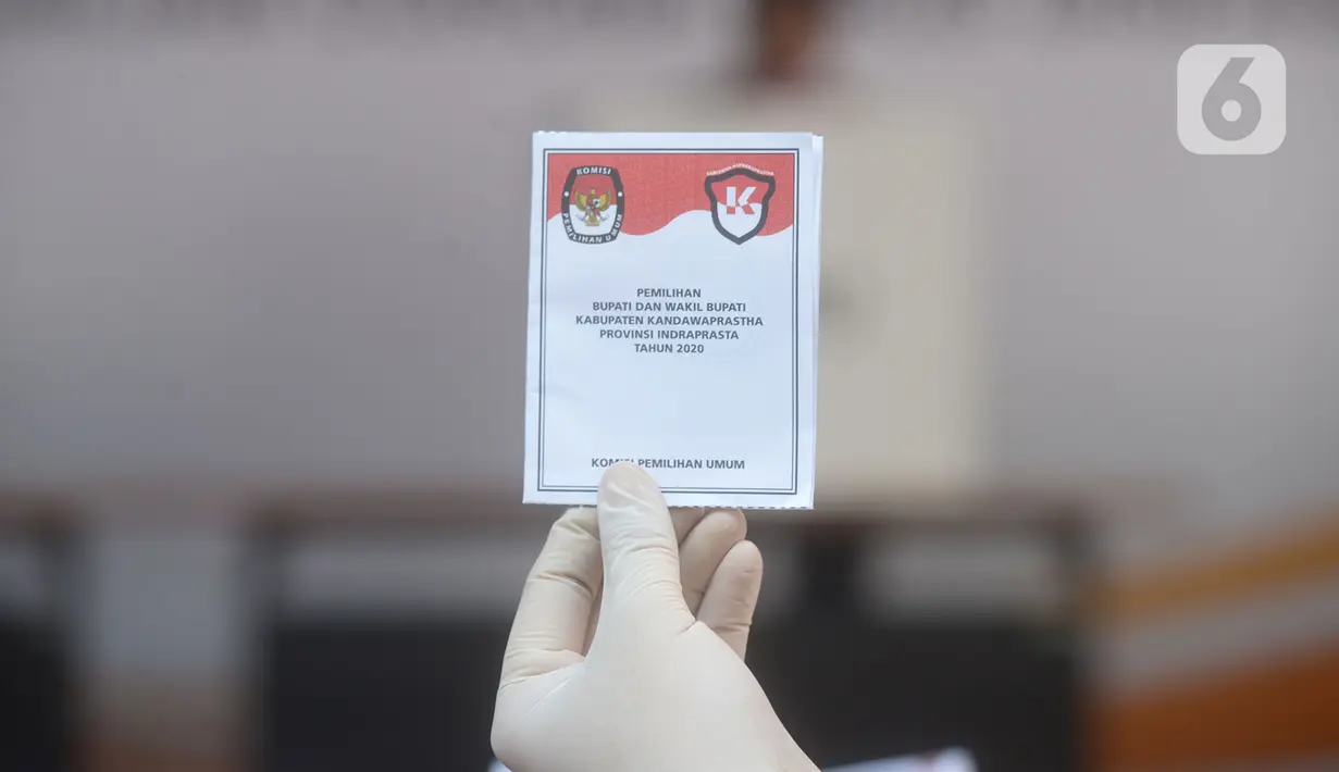 Petugas menunjukkan surat pemungutan suara dalam pemilihan serentak 2020 saat simulasi di Halam Kantor KPU, Jakarta, Rabu (22/7/2020). Tahapan ini dilaksanakan dengan mengutamakan aspek kesehatan dan keselamatan bagi para pihak yang terlibat. (merdeka.com/Imam Buhori)