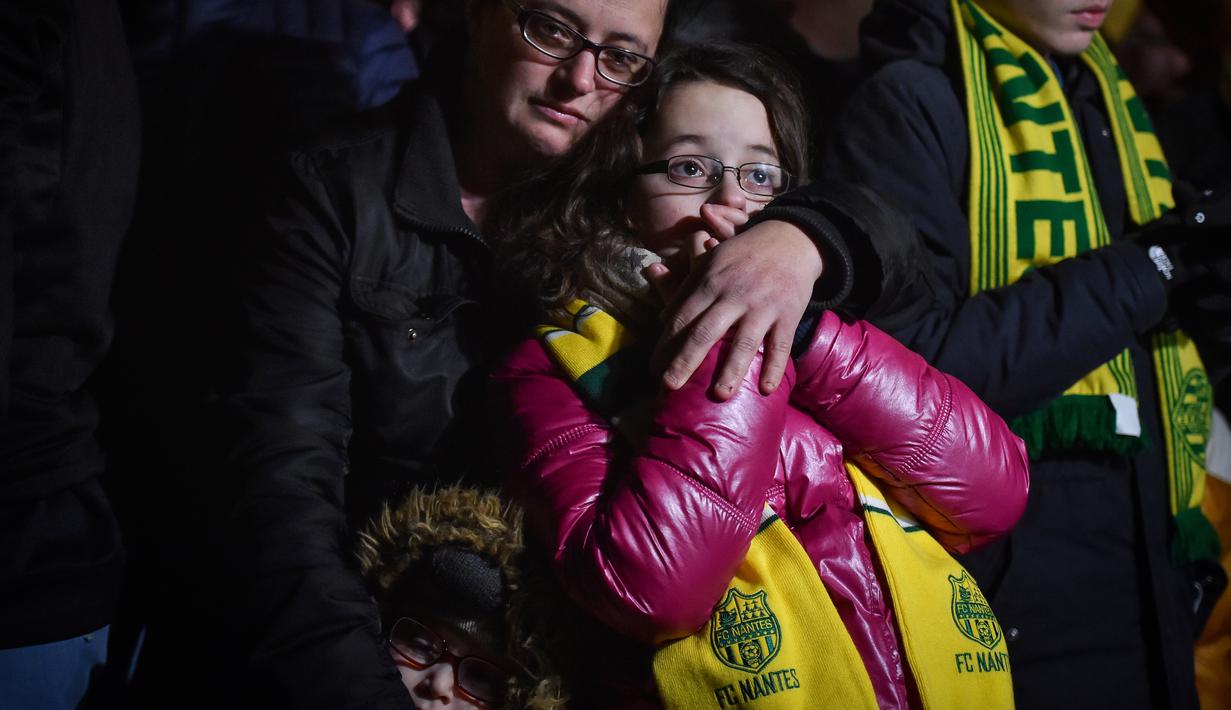Ekspresi pendukung FC Nantes yang larut dalam kedukaan. Hal tersebut terjadi setelah mendengar kabar mantan bintang mereka, Emiliano Sala tewas karena pesawat yang ditumpanginya hilang dari kontak. (AFP/Loic Venance)