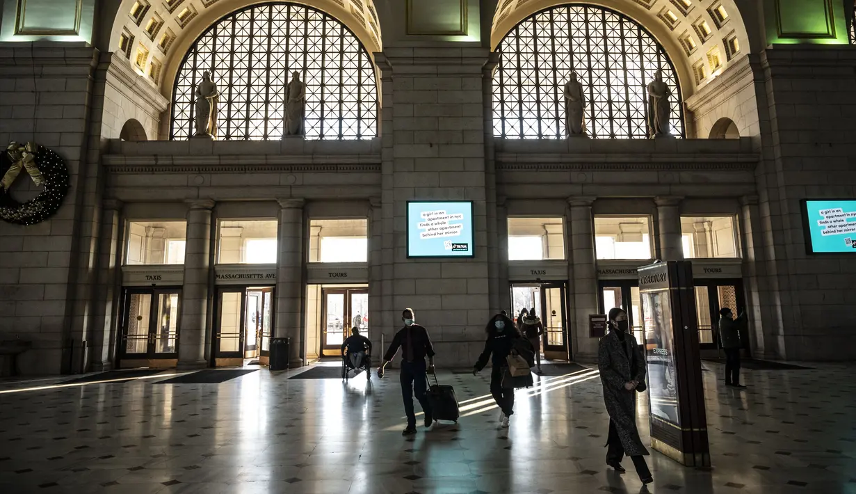 Orang-orang tiba di stasiun kereta Union Station di Washington, DC, Kamis (23/12/2021). Jutaan orang Amerika bepergian pada 23 Desember 2021, selama salah satu hari perjalanan tersibuk di musim liburan, ketika infeksi Covid dengan Omicron melampaui puncak gelombang varian Delta. (Pedro Ugarte/AFP)