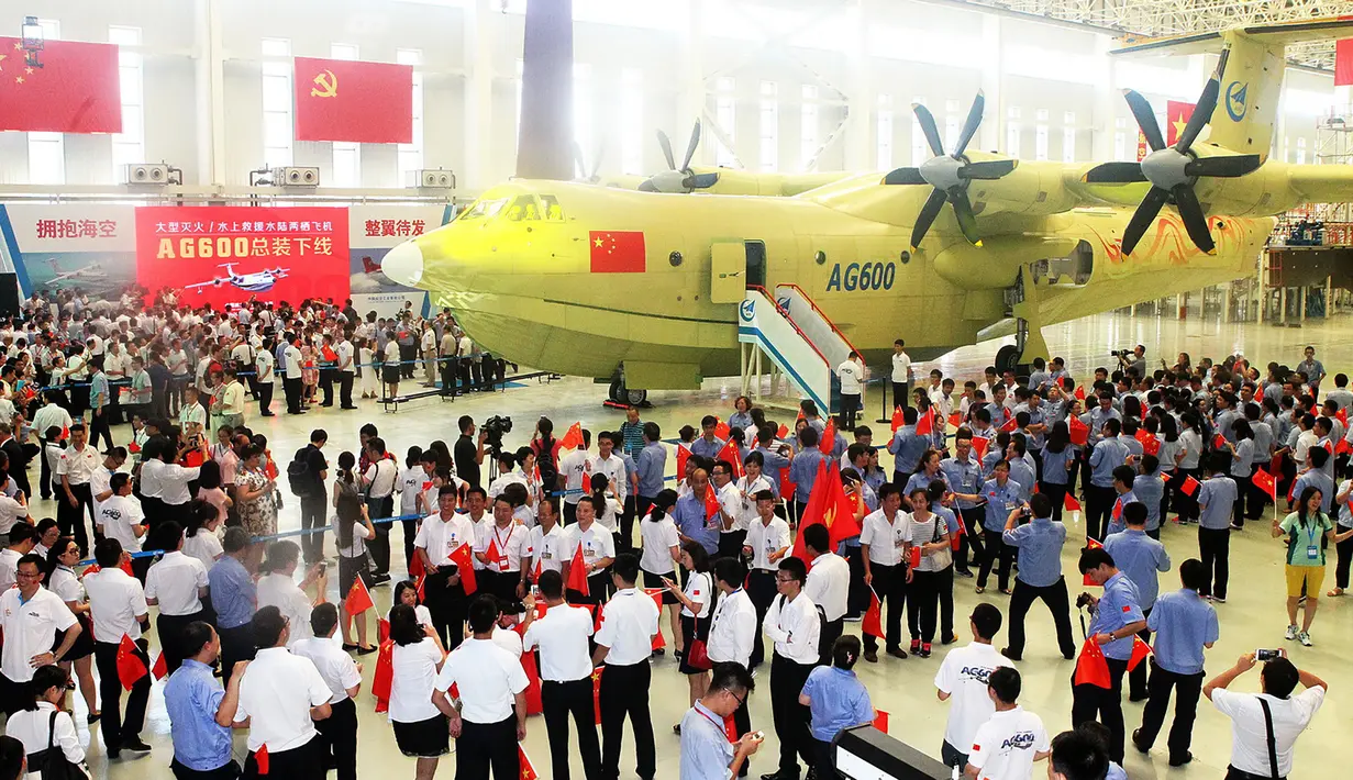 Sejumlah pekerja saat mengikuti peluncuran pesawat Amfibi AG600 di Zhuhai, Guangdong, China, (23/7). AG600 merupakan pesawat amfibi terbesar di dunia yang dibangun untuk misi maritim dan memadamkan kebakaran hutan. (AFP PHOTO/STR/Cina OUT)