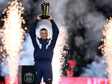 Penyerang Paris Saint-Germain Kylian Mbappe mengangkat trofi selama upacara setelah menjadi pencetak gol terbanyak sepanjang sejarah klubnya selepas pertandingan Ligue 1 Prancis antara PSG dan FC Nantes di Parc de Princes, Minggu (5/3/2023) dini hari WIB. Kylian Mbappe menorehkan pencapaian baru bersama klubnya PSG. (FRANCK FIFE / AFP)