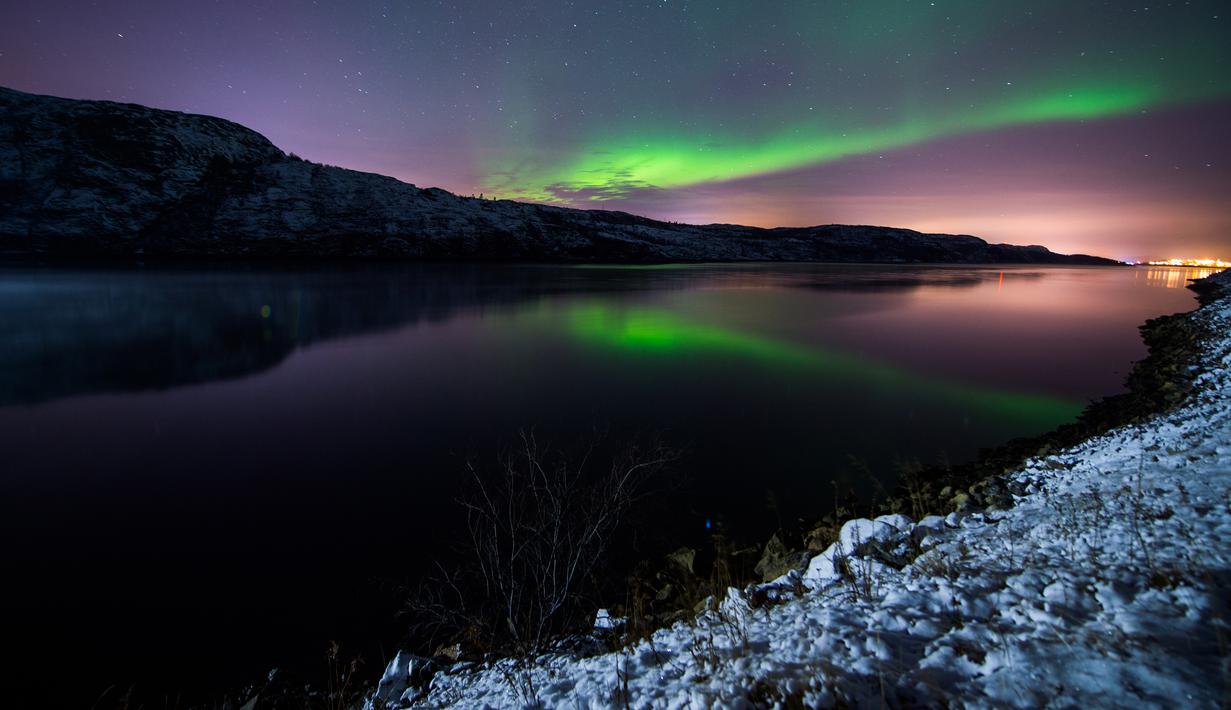 Cahaya berwarna kehijaun tampak menerangi langit malam saat fenomena aurora borealis di dekat kota Kirkenes, Norwegia utara, Kamis (12/11/2015). (AFP PHOTO/Jonathan NACKSTRAND)