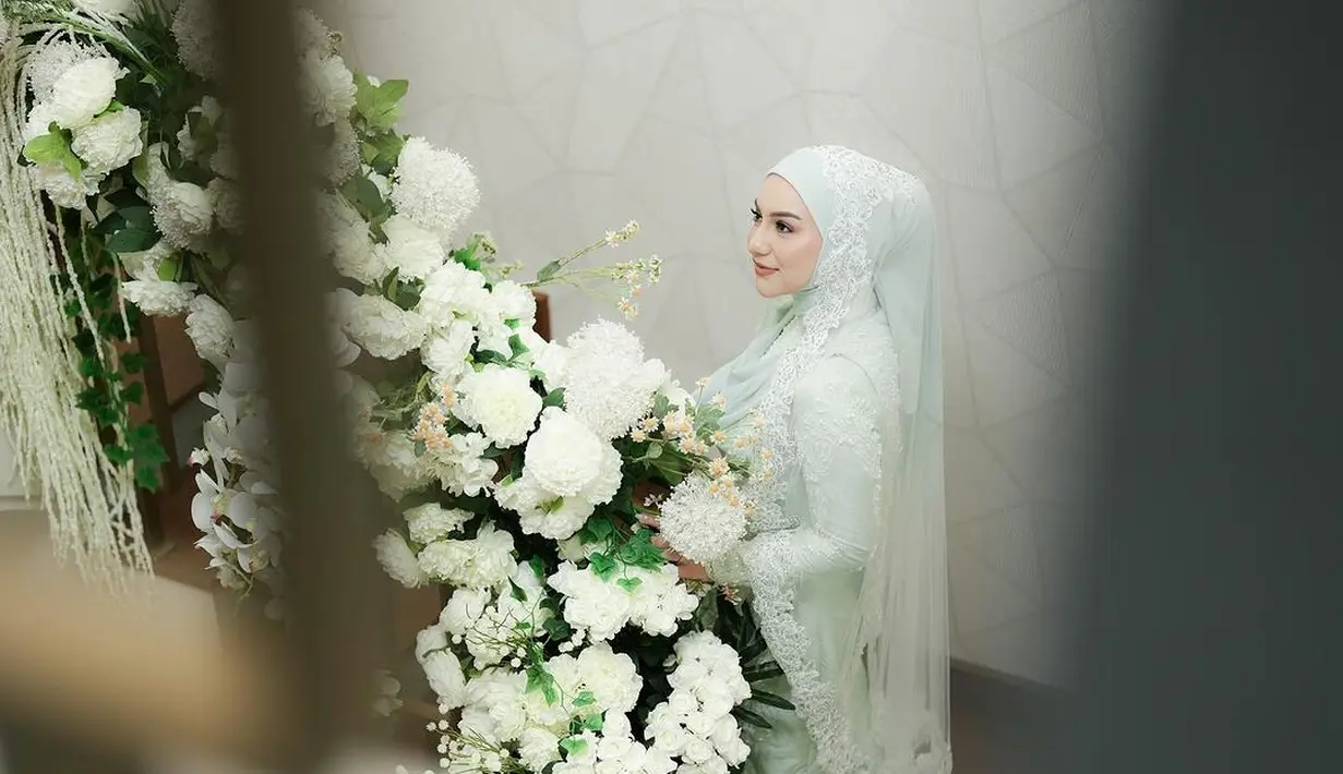 Irish Bella nampak kenakan kebaya kurung panjang yang dipadukan dengan kain tenun berwarna hijau mint rancangan Dimas Singgih.