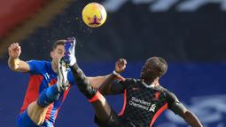 Striker Liverpool, Sadio Mane, berebut bola dengan bek Crystal Palace, Gary Cahill, pada laga lanjutan Liga Inggris di Selhurst Park Stadium, Sabtu (19/12/2020) malam WIB. Liverpool menang 7-0 atas Crystal Palace. (AFP/Adam Davy/pool)