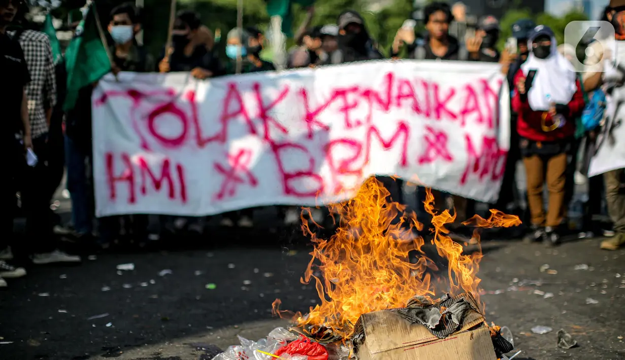 Api berkobar saat sejumlah mahasiswa dari berbagai universitas menggelar aksi di depan Gedung DPR, Jakarta, Selasa (6/9/2022). Dalam aksi tersebut mahasiswa menolak keputusan pemerintah menaikkan harga bahan bakar minyak (BBM) bersubsidi dan meminta pemerintah untuk meninjau ulang keputusan tersebut. (Liputan6.com/Faizal Fanani)