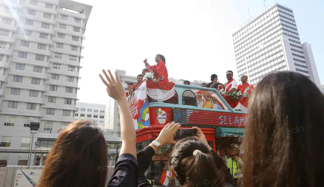 Sambutan hangat dari karyawan untuk Tontowi Ahmad, Liliyana Natsir, Eko Yuli dan Sri Wahyuni saat parade dengan bus Bandros menuju Istana Negara, Rabu (24/8/2016). (Bola.com/Nicklas Hanoatubun)