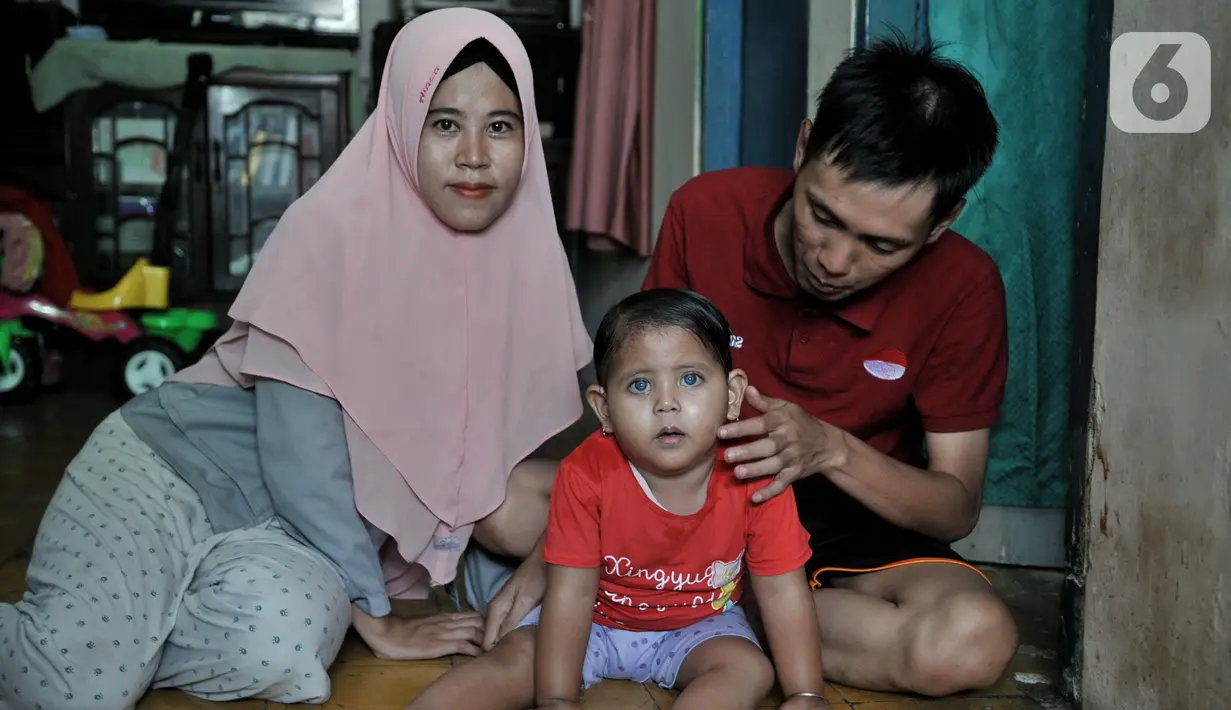 Fauziah Afiqa (tengah) berpose dengan ayah dan ibunya di kediamannya di Kampung Bulak Sentul, Harapan Jaya, Bekasi, Jawa Barat, Kamis (10/10/2019). Afiqa merupakan keturunan Betawi asli pasangan Ahmad Fauzi (26) dan Dian Irna Kurniawati (25). (merdeka.com/Iqbal Nugroho)