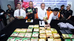 Direktur Tidpid Narkoba Bareskrim Polri Brigjen Eko Daniyanto (ketiga kiri depan) melihat barang bukti narkotika jenis sabu saat rilis di Jakarta, Senin (16/10). Empat tersangka serta sabu 30 Kg ditahan petugas. (Liputan6.com/Helmi Fithriansyah)