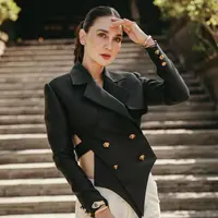 Luna Maya tampil elegan mengenakan setelan cut-out blazer hitam rancangan desainer tanah air Hian Tjen. Blazer ini memiliki detail ujung V dan kancing emas yang menambah nuansa mewah. Foto: Instagram.
