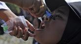 Seorang anak menerima imunisasi polio dari petugas medis saat berlangsung vaksinasi massal di Sigli Town Square,  Pidie, Aceh, Senin (28/11/2022). Kementerian Kesehatan melakukan vaksinasi massal sebanyak 1.000 anak dari target target 9.940 anak. (AP Photo/Riska Munawarah)