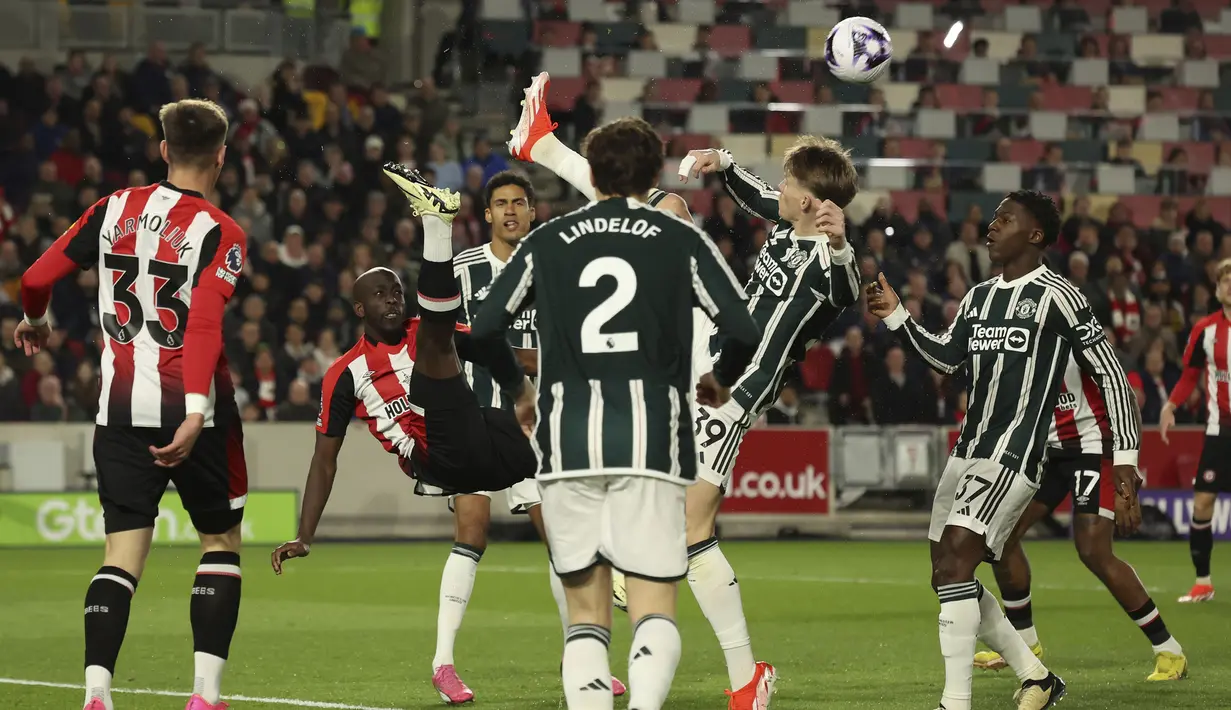 Striker Brentford Yoane Wissa (kedua kiri) berebut bola dengan gelandang Manchester United, Scott McTominay dalam sebuah kemelut di depan gawang MU pada laga pekan ke-30 Premier League 2023/2024 di Gtech Community Stadium, London, Sabtu (30/3/2024). (AP Photo/Ian Walton)