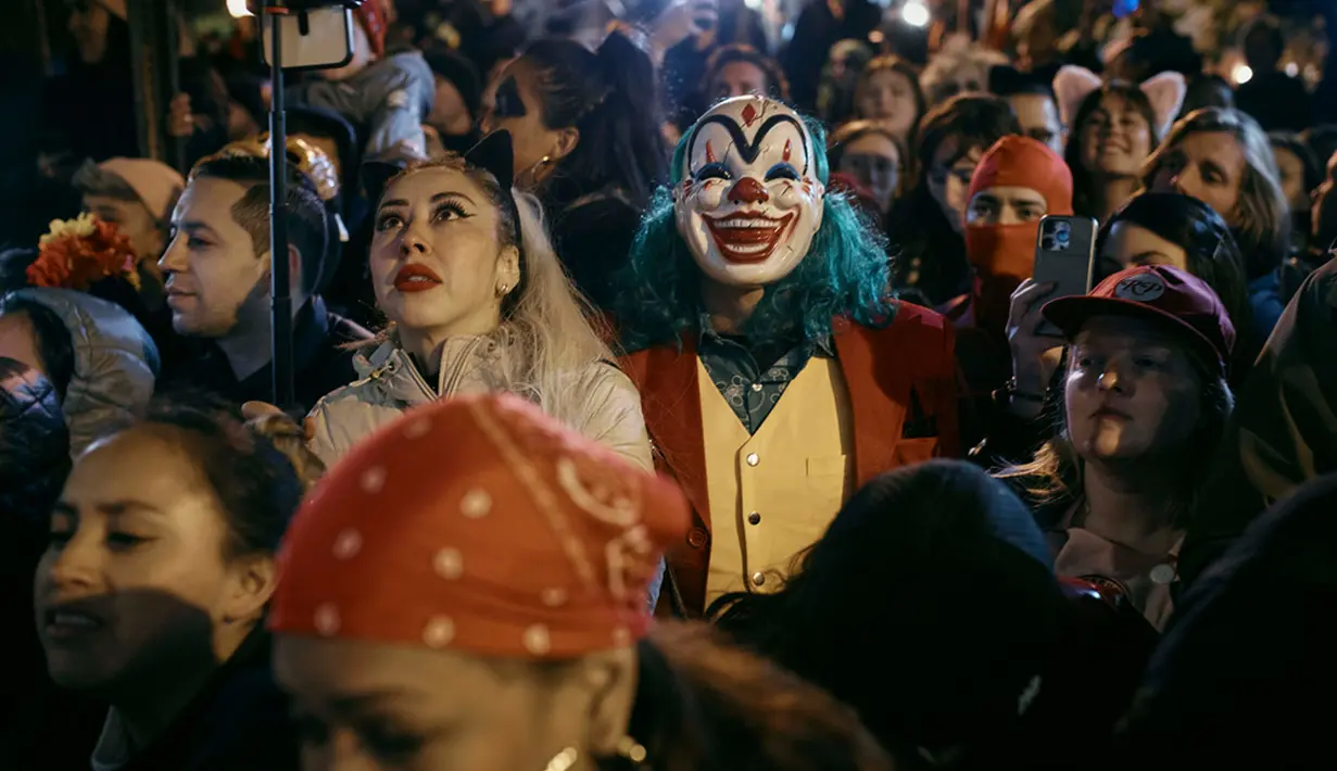 Peserta yang mengenakan kostum Joker berdiri di antara pengunjung saat acara Village Halloween Parade di New York, Amerika Serikat, Selasa (31/10/2023). (AP Photo/Andres Kudacki)