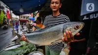 Pedagang menunjukkan ikan bandeng di kawasan Rawa Belong, Jakarta  Barat, Jumat  (9/2/2024). (Liputan6.com/Angga Yuniar)