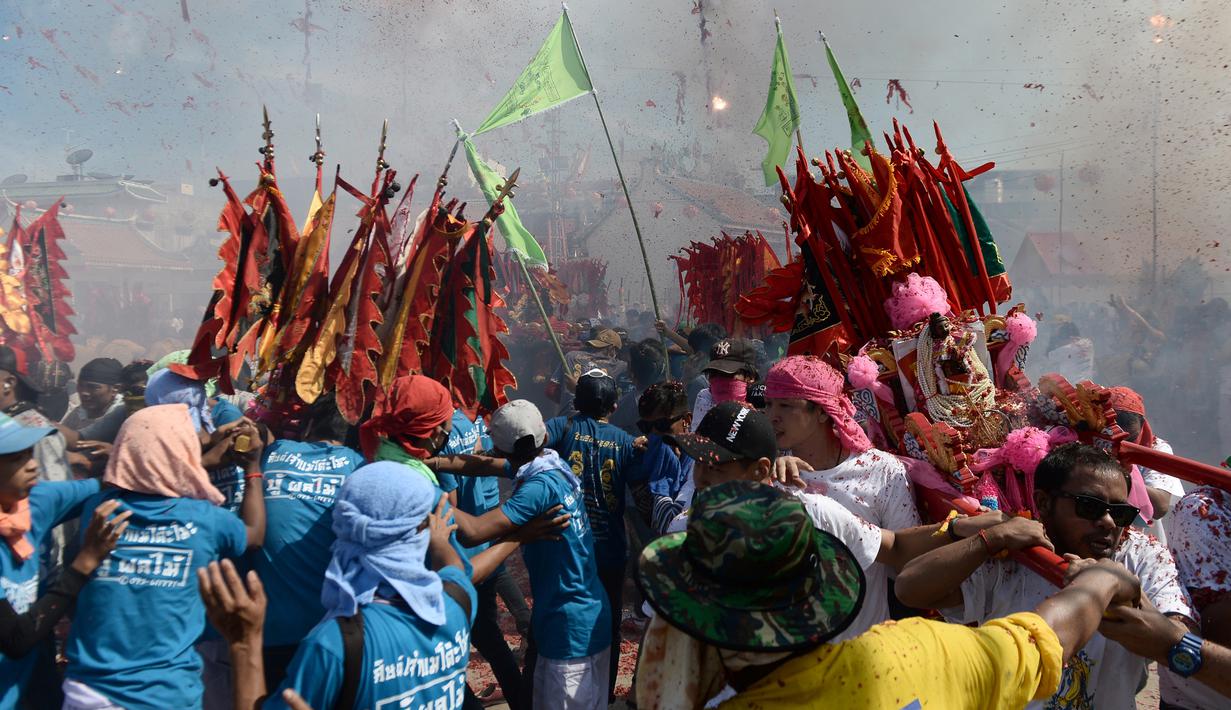 Sejumlah warga menyalakan petasan saat merayakan festival keagamaan tahunan untuk Dewi yang sangat dihormati dari Kuil Chao Mae To Mo di distrik Sungai Kolok, Thailand (8/5). (AFP/Madaree Tohlala)