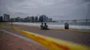 Sepasang kekasih duduk di pantai yang ditutup di kawasan pejalan kaki di pantai Gwangalli di Busan (2/9/2020). Penerbangan dihentikan di Korea Selatan dan peringatan badai dikeluarkan di kedua sisi semenanjung Korea sebagai topan yang diperkirakan akan menjadi salah satu yang terkuat. (AFP/Ed Jones)