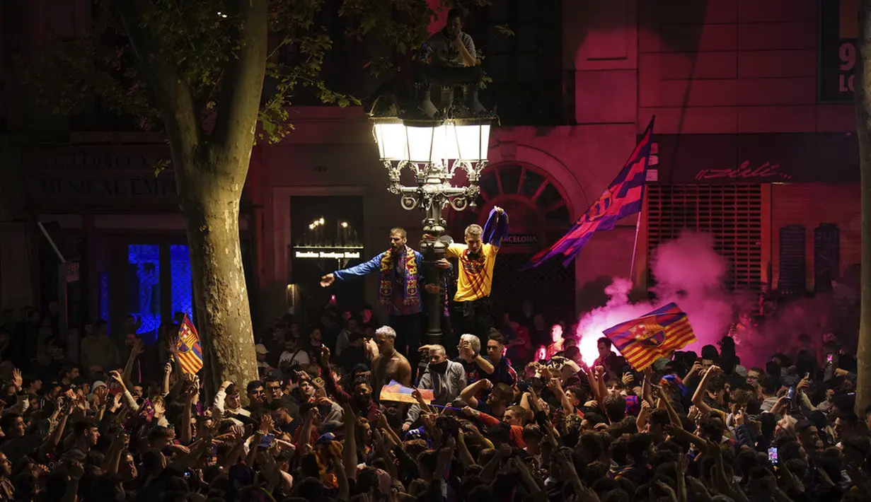 <p>Kerumunan suporter memenuhi jalan-jalan Kota Barcelona. Mereka merayakan gelar juara La Liga Spanyol yang diraih Barcelona. (AP Photo/Joan Mateu Parra)</p>