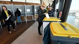 Warga memasukkan surat suara ke tempat sampah yang disulap menjadi kotak suara saat pemilihan umum Belanda di sebuah TPS di Menara A'Dam, Amsterdam, Rabu (15/3). Pemilu ini untuk menentukan siapa perdana menteri Belanda selanjutnya (AP Photo/Patrick Post)